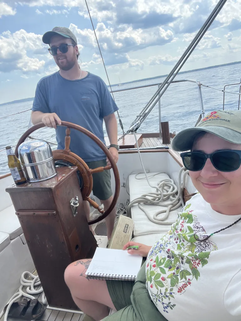 Ian steering a boat while sel draws